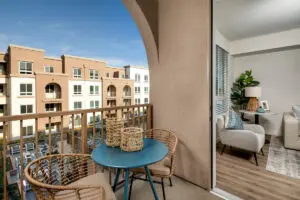 Model balcony at Alta Merita Apartments in Rancho Cucamonga, featuring outdoor furniture and wood grain floor paneling.
